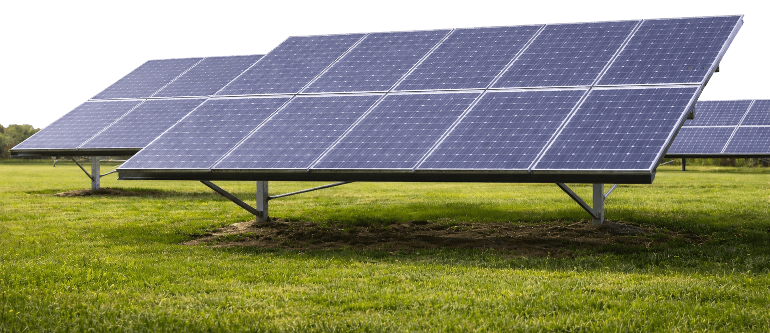 Solar panels on a grassy field under a clear sky.